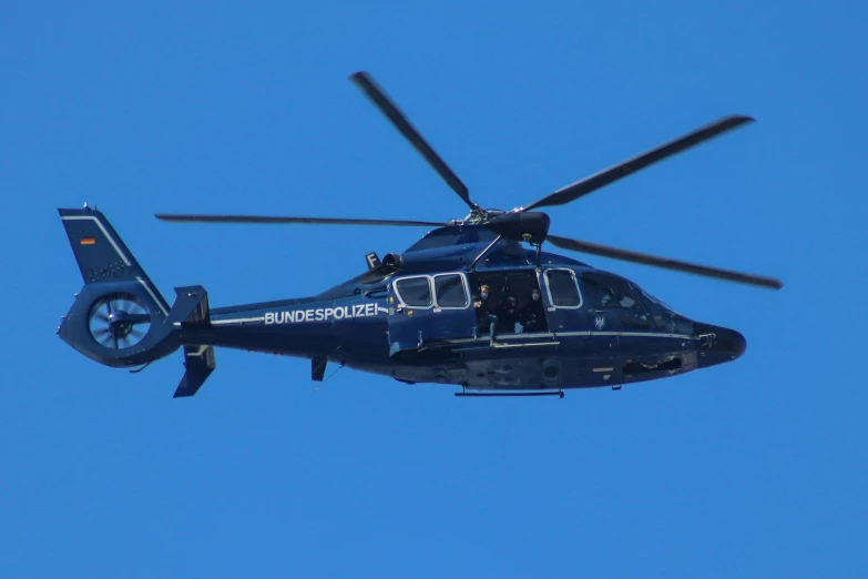 a helicopter flying through the air during the day