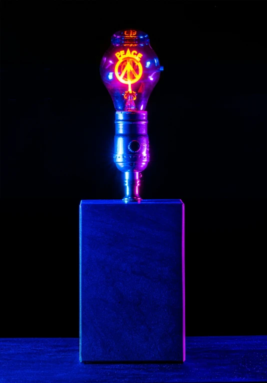 a neon light bulb lit up on top of a small object