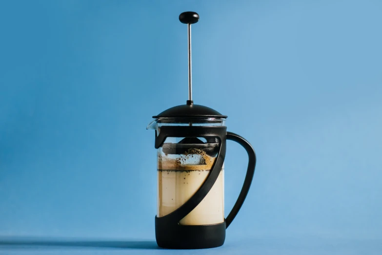 a pitcher with an unusual handle filled with coffee