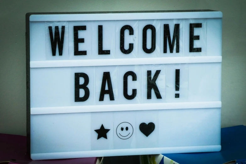 a welcome back sign lit up for someone