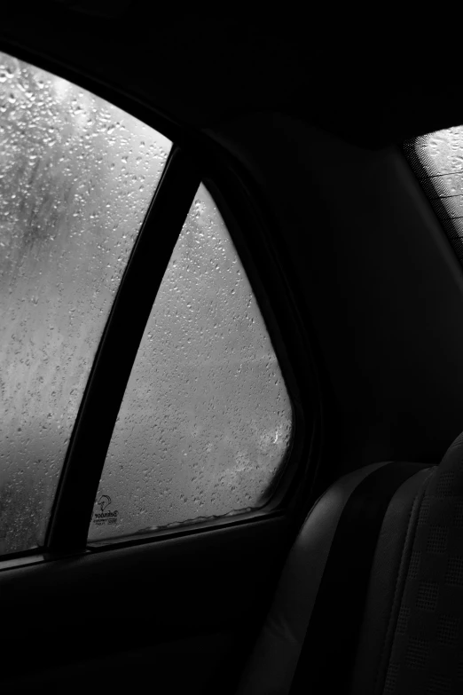 a car's rear window as it is raining