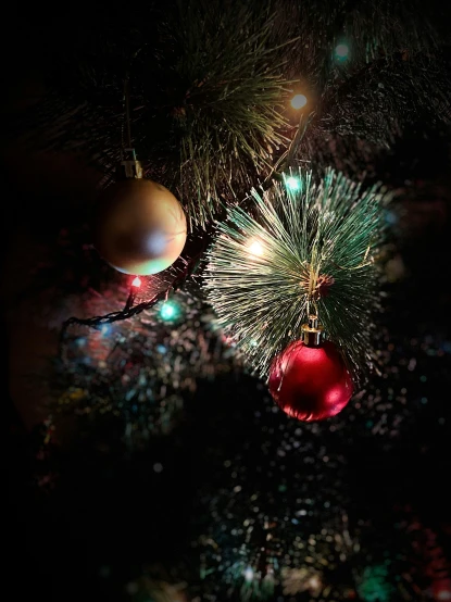 balls, fir - needles and lights adorn a christmas tree