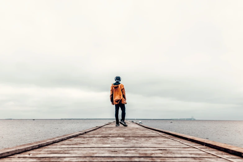 a person standing on a dock by a body of water