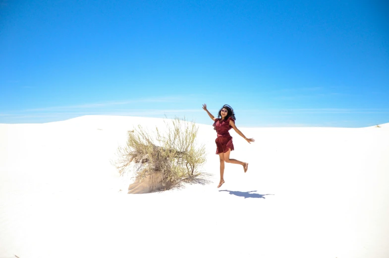 a woman is running in the desert holding a frisbee