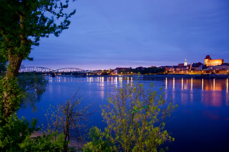 a river that is blue with lights on at dusk