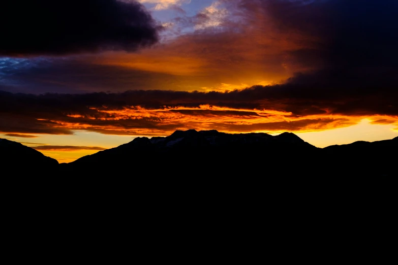 a group of mountains with a sky full of clouds