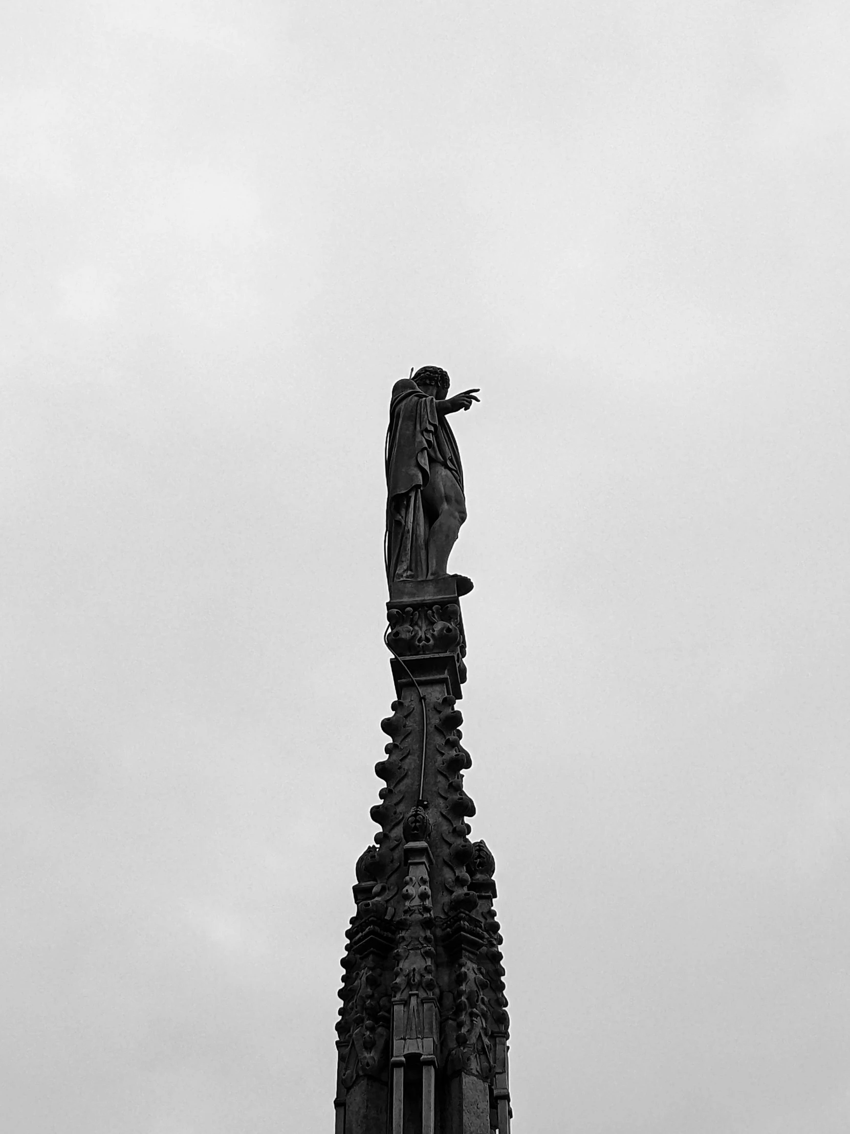 a very tall statue standing next to a very large building