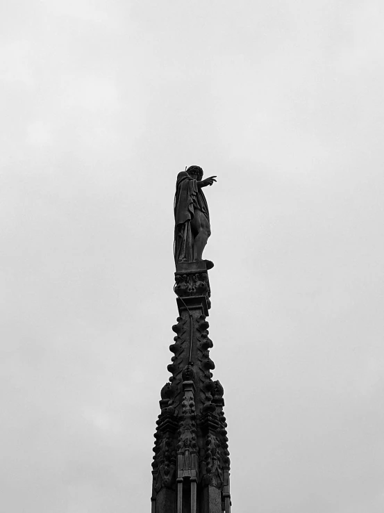 a very tall statue standing next to a very large building