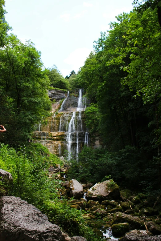 a man taking a po near a waterfall