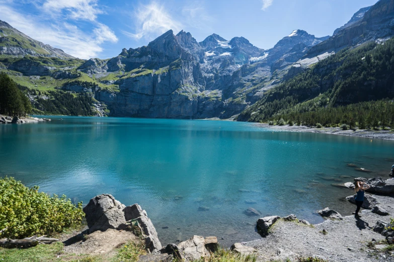 a lake with some rocks and mountains in the background