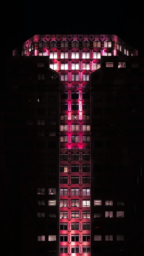 a large tall building has neon lights on it