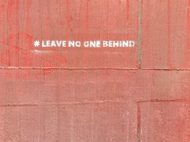 red, black, and white poster on a wall stating leave this behind