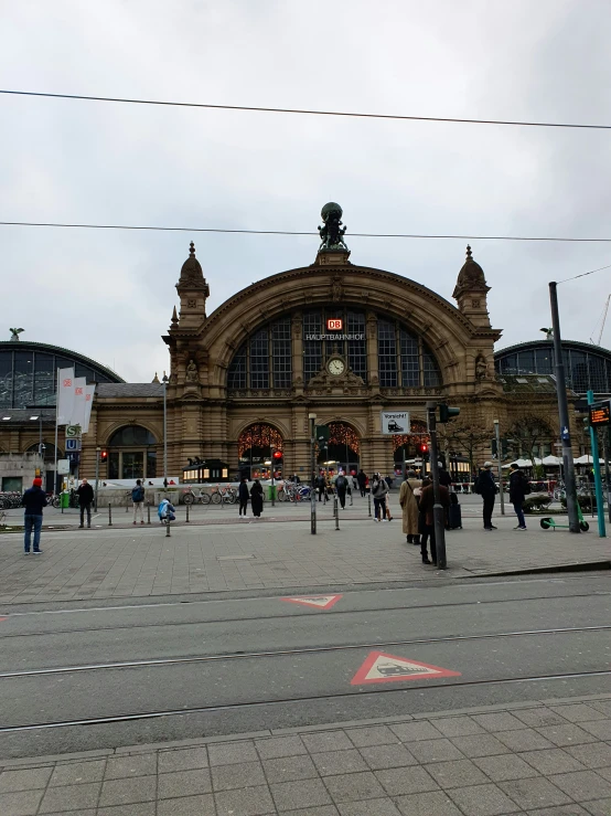 people walking around at a train station near a train