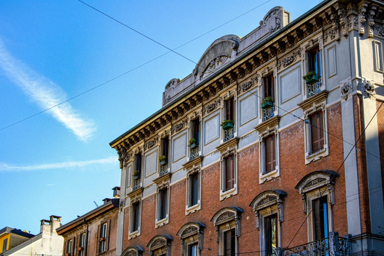 a tall brown and tan building with some blue windows