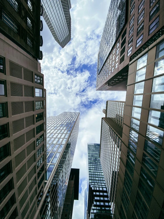 looking up at tall buildings on a cloudy day