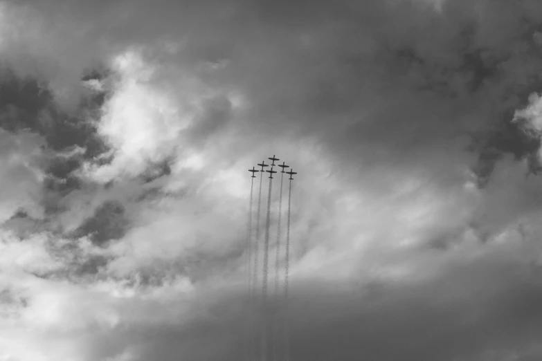 three jets in flight in front of the cloudy sky