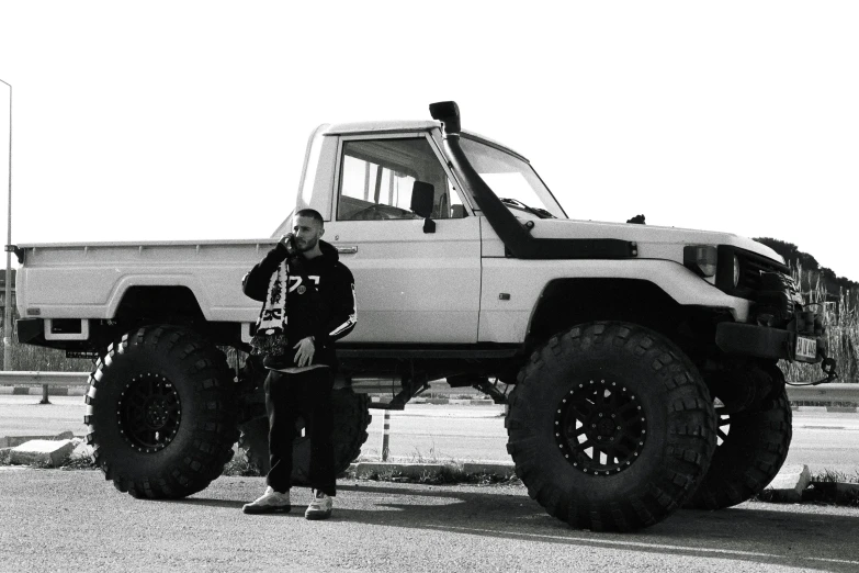 a person is standing next to a giant monster truck