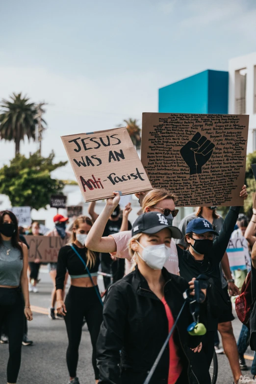 protestors holding protest signs and standing around each other