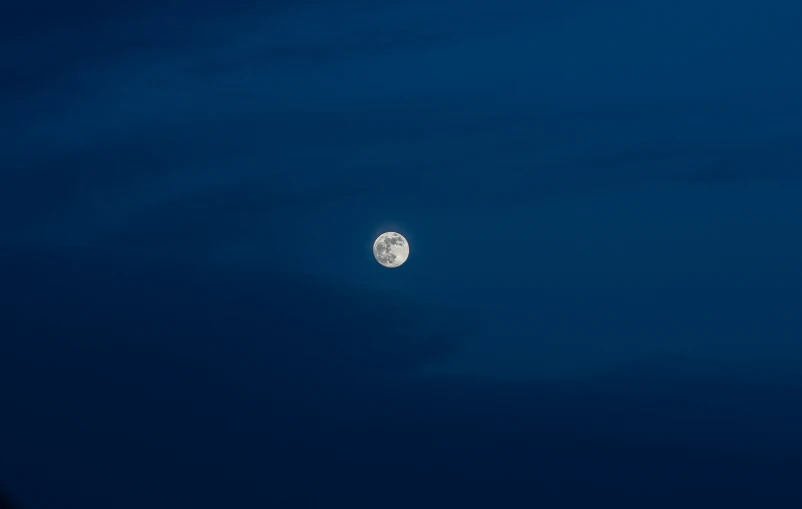 the moon shines in the night sky over a building