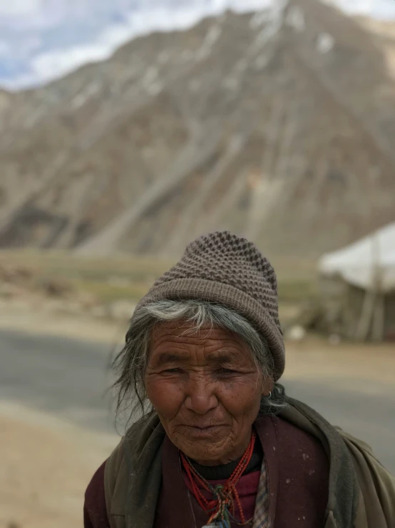 a woman standing on the street with mountain in background