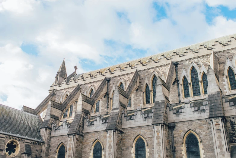 an old cathedral against a sky with white clouds