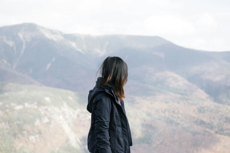 a person looking over a mountainous area, looking off to the left