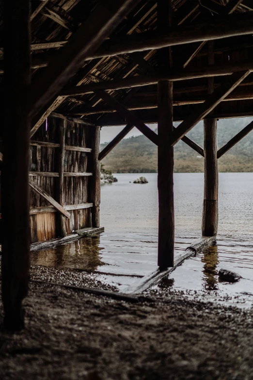 the inside of a wooden structure that is in some water