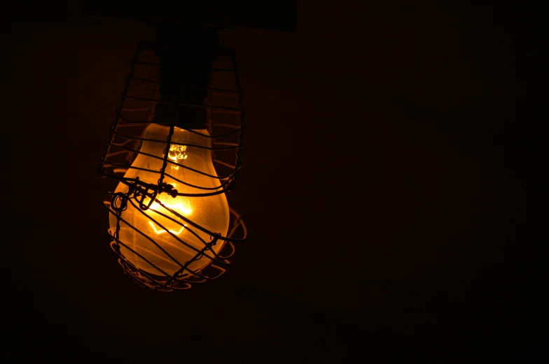 a lit bulb in the dark that is turned on