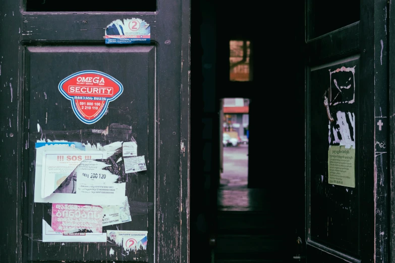 an old door with several different stickers hanging