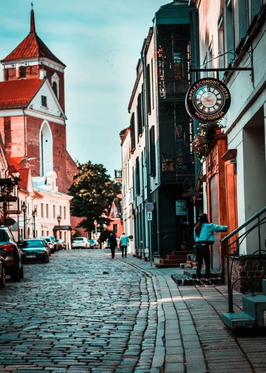 a man skateboards on the cobblestone road in front of many houses