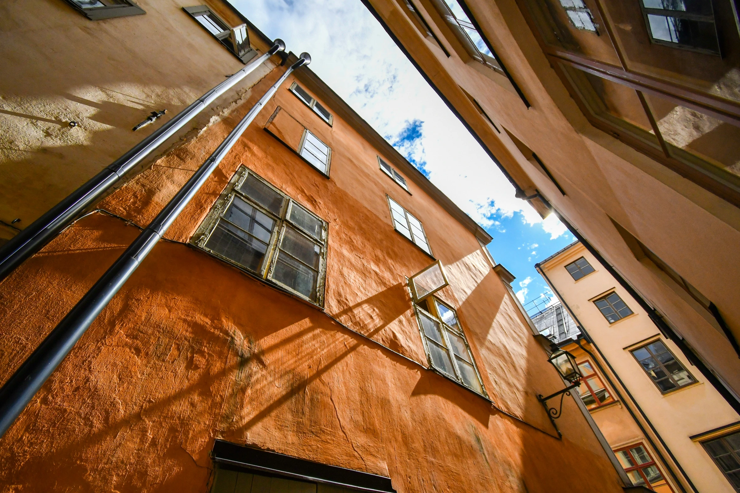 looking up at some orange building with window blinds