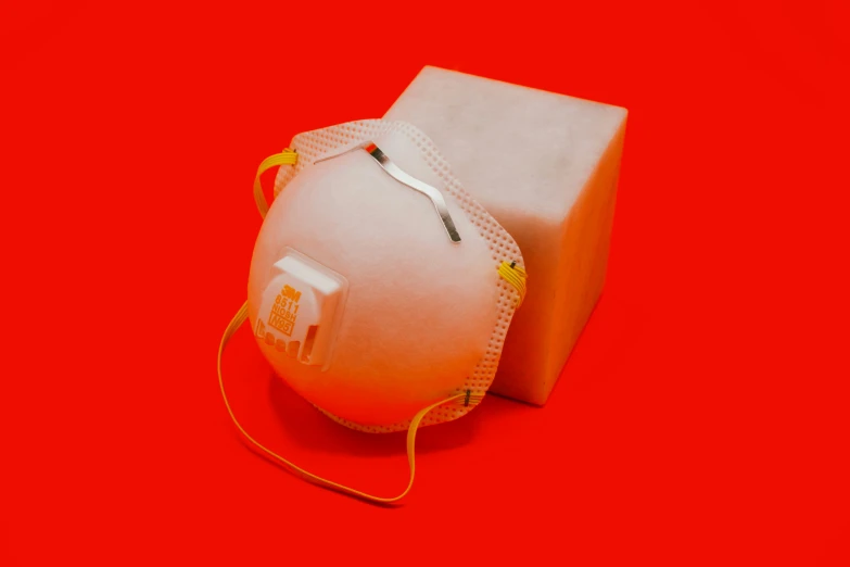 a white object with yellow cords attached is sitting on a red surface