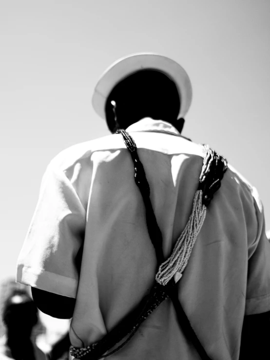 back view of man in dress shirt and tie with a hat on