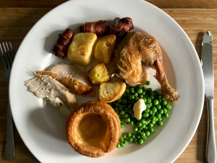 a white plate with food on it and a fork next to the plate