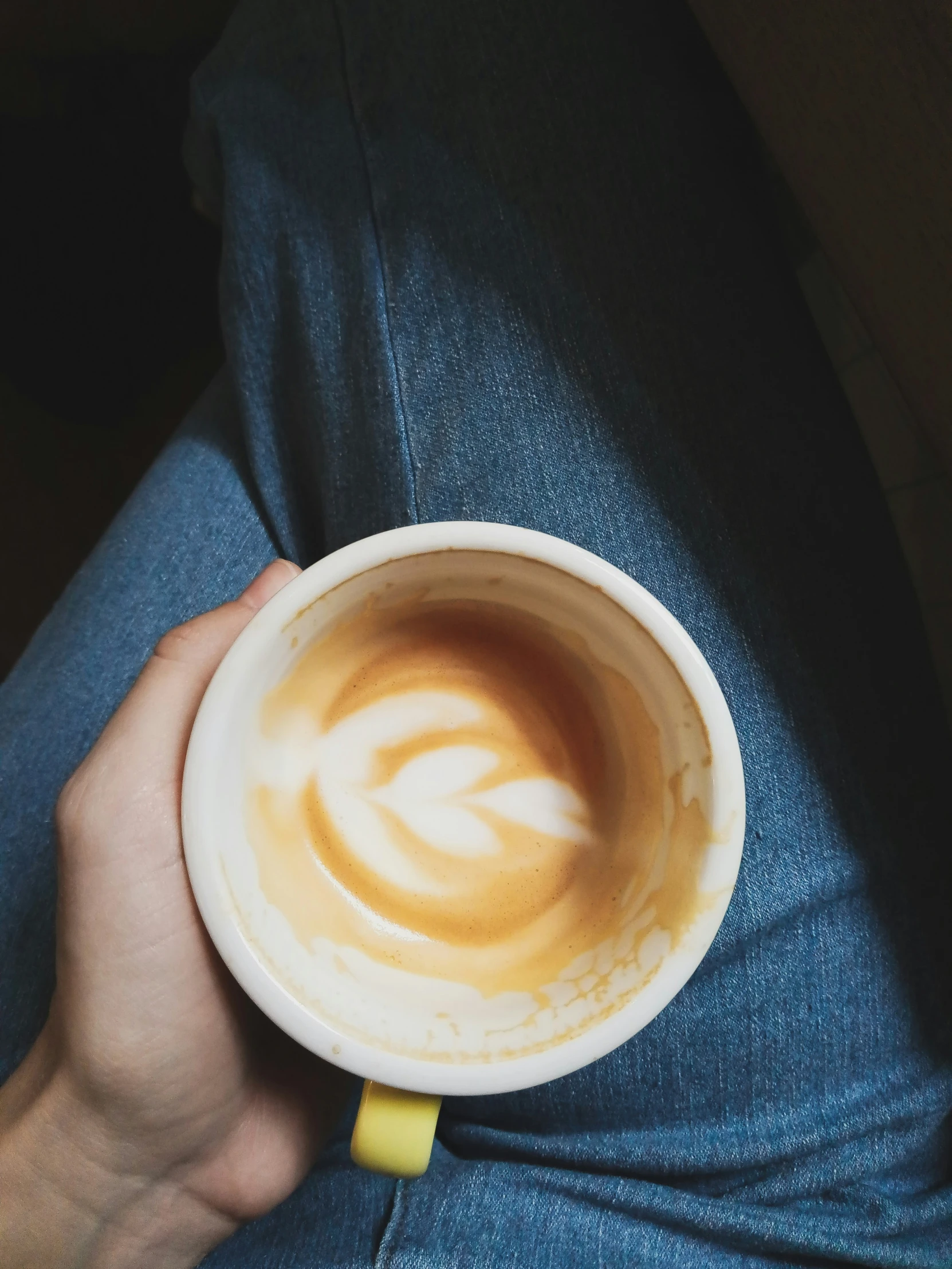 a person with dark hair holds a cup of liquid