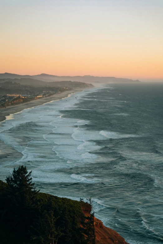 a sunset overlooking the beach next to an ocean