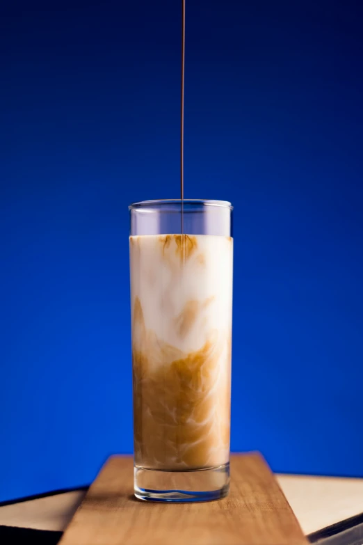 a glass on a table with liquid inside