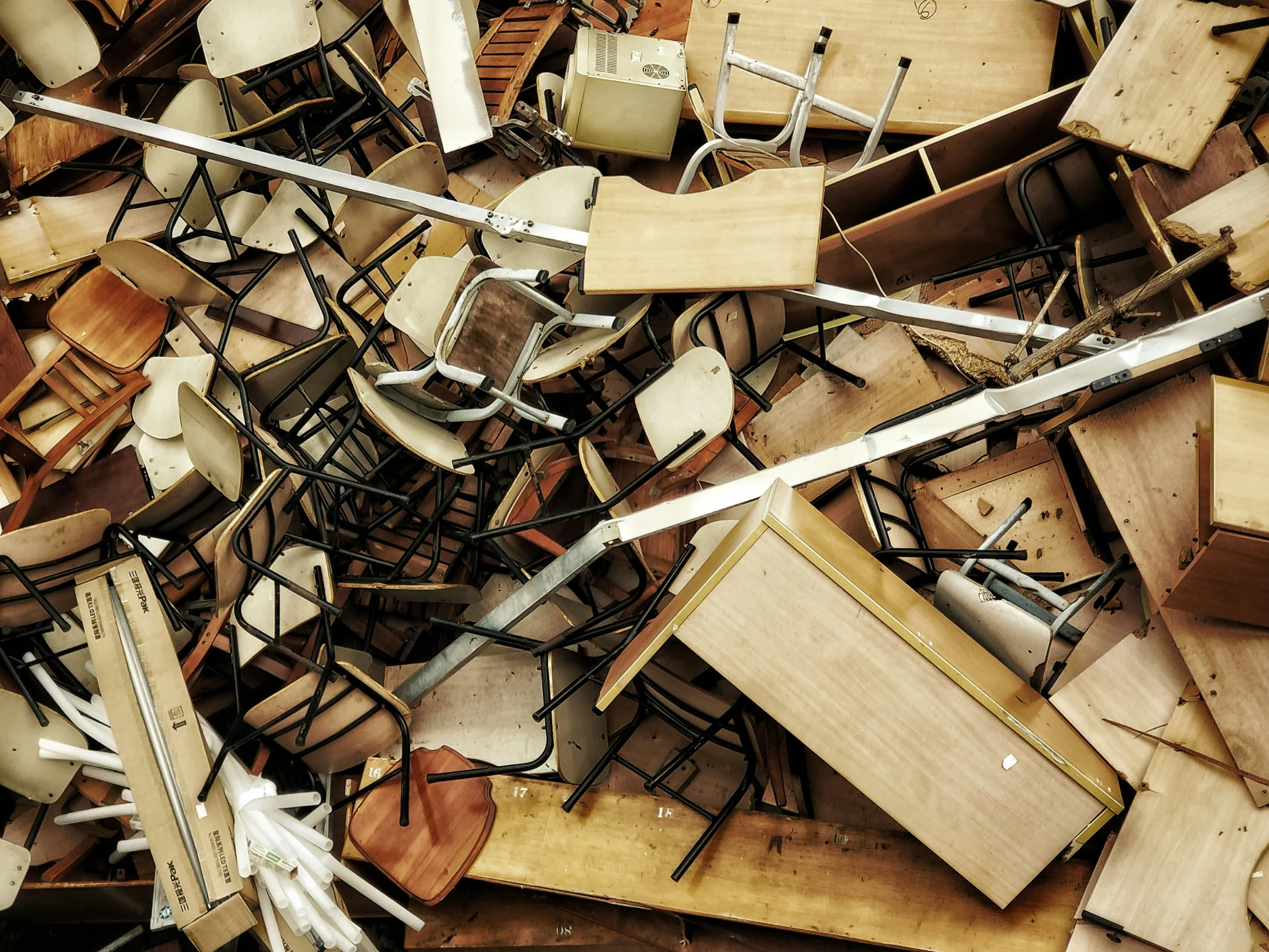 lots of wooden chairs and tables piled up together