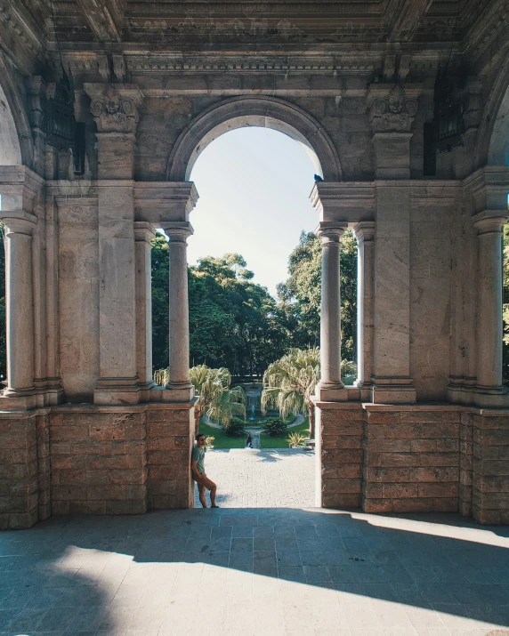 two people sit on the bench under an archway