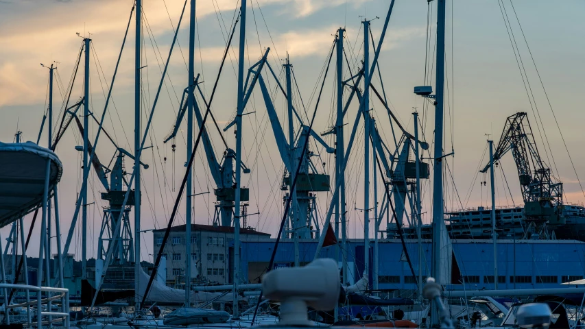 a dock with many cranes next to a large building