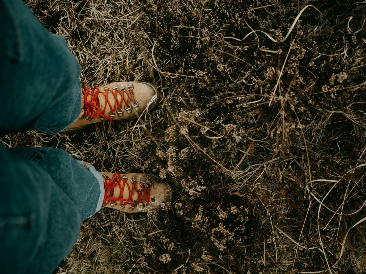 the feet of a person who is standing on some grass