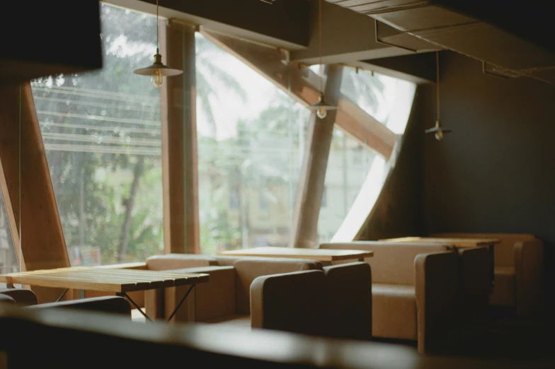 a bunch of wooden desks near a large window