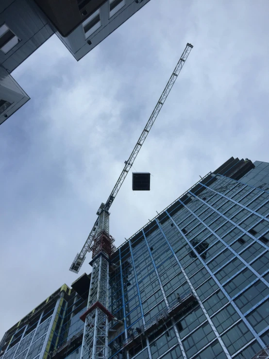 a crane stands in front of a tall building