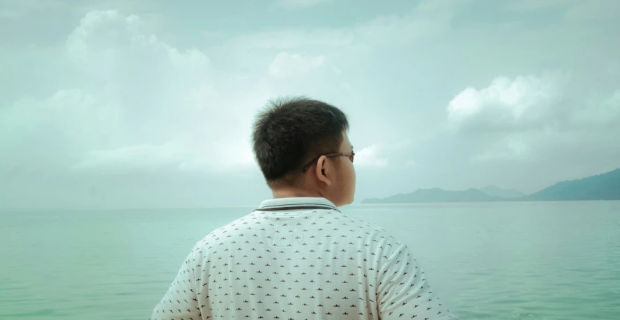 man looking out to sea from a boat