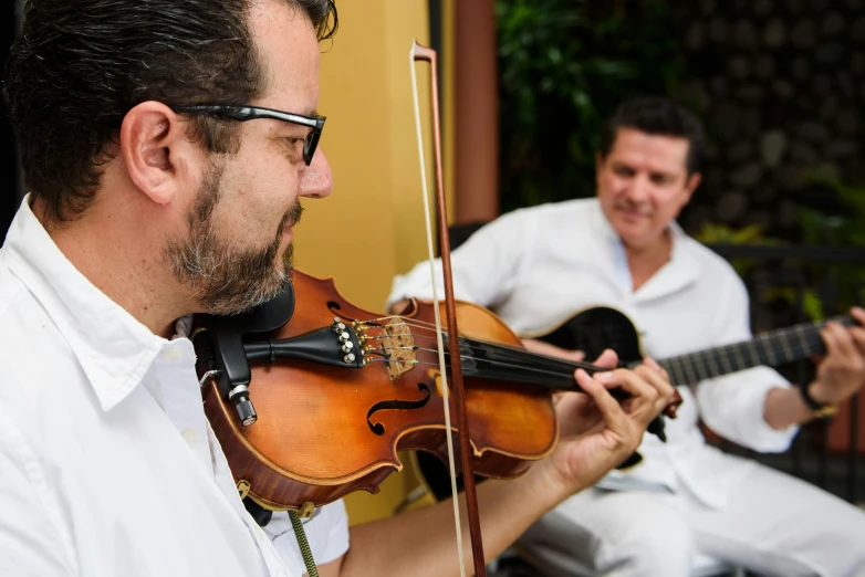 the man is playing the violin and other musicians