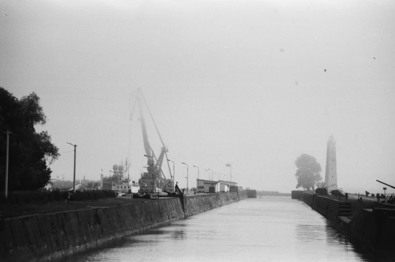 boats floating on the water with trees and buildings in the background