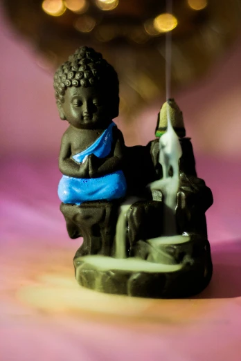 a figurine of a boy sitting on top of a chair with a fish