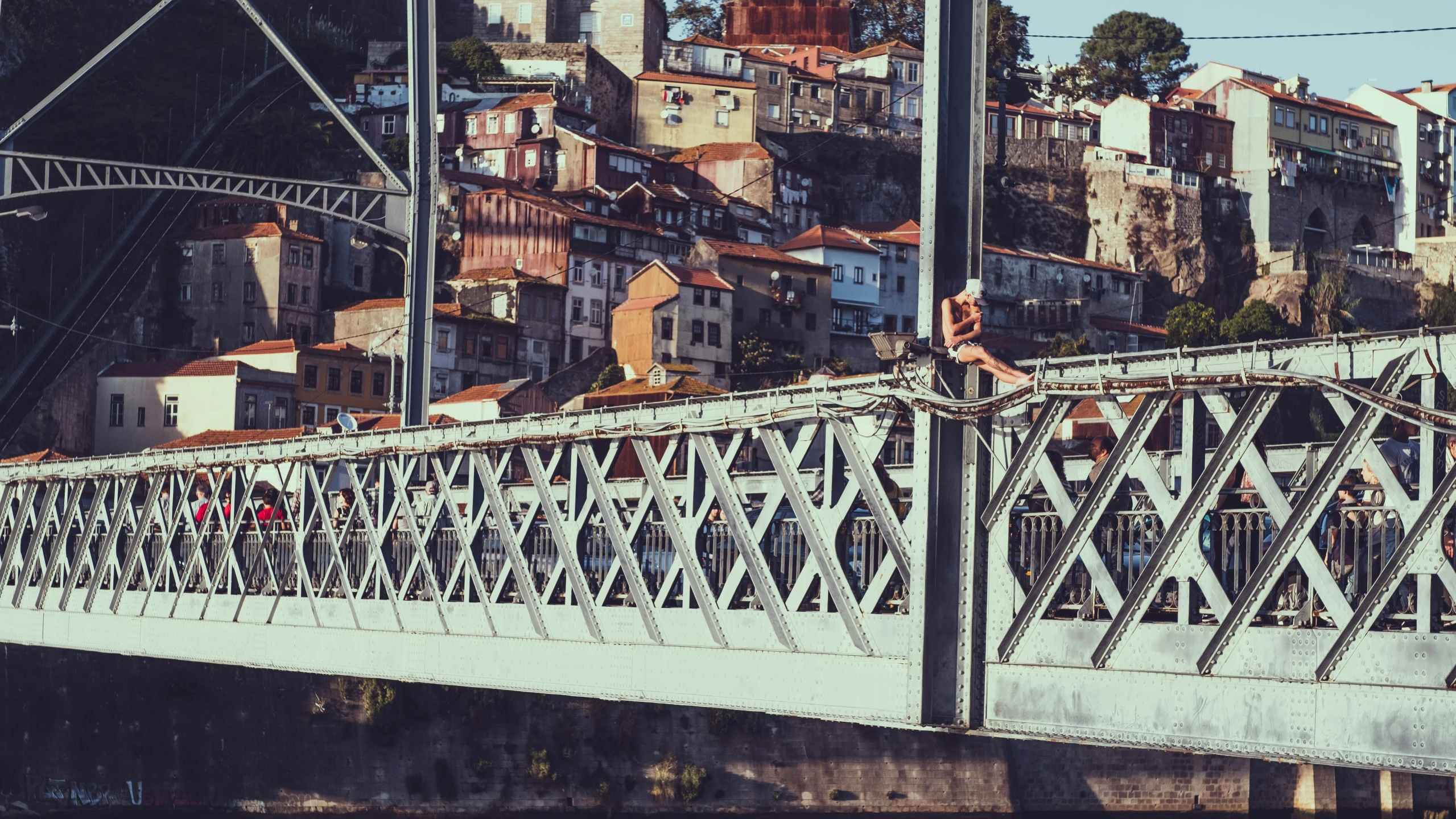 a man skateboards on a bridge in front of a city