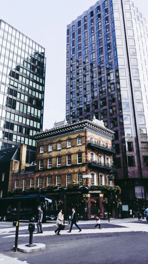 people walking across a street in a city with buildings