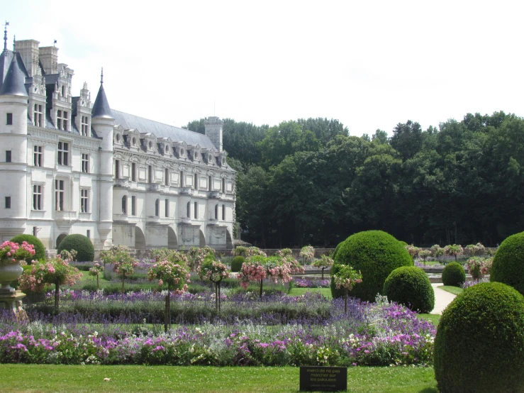 a very big pretty building with lots of plants